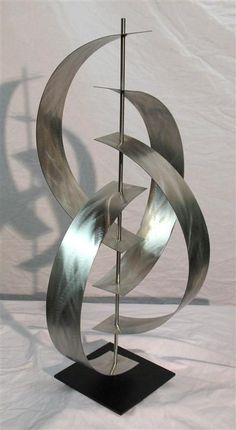 a metal sculpture is shown on a black stand