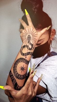 a woman holding her hand up to her face with the sun and moon tattooed on it