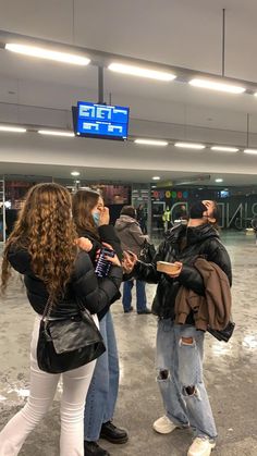 several people standing in an airport waiting for their luggage to be picked up or taken off