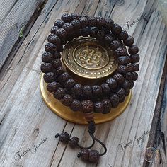 "This attractive and powerful Japa Mala is made with Rudraksha bead that are naturally stained and oiled to achieve their beautiful dark color and aged appearance.  📿Mala Beads, or Buddhist prayer beads, are a set of sacred rosary beads for chanting & counting mantras, meditation, prayer, yoga & reflection. Mala is a Sanskrit word meaning garland. The Tibetan word for mala is threngwa (Tibetan  ཕྲེང་བ) . Seed malas are some of the most common malas used in Tibet and Nepal. Buddhist Prayer Beads are sometimes referred to as Japa mala, japa is a Sanskrit word meaning \"repeat internally\".📿 Specifications  * 108 Rudraksha Seed (9-9.5mm approx.) soaked in oil to get darker color plus 14mm Guru Bead  * This mala is hand strung on durable knotting cord * Fixed knot closure * Total Mala Length Spiritual Brown Mala For Festivals, Brown Spiritual Mala For Festivals, Spiritual Black Beads Mala For Meditation, Traditional Black Mala With 108 Beads, Spiritual Mala With Round Beads For Festival, Adjustable Spiritual Mala For Puja, Black Beads Mala For Meditation, Black Beaded Mala For Meditation, Brown 8mm Beads Mala For Festival