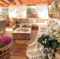 a living room filled with lots of wicker furniture and flowers on the table in front of it