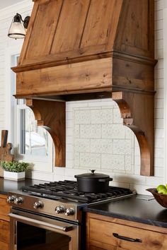 a stove top oven sitting inside of a kitchen next to wooden cabinets and counter tops