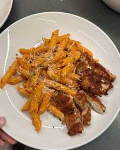 a white plate topped with cheesy pasta and chicken