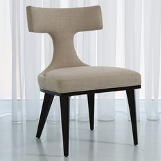 a beige chair sitting in front of a window