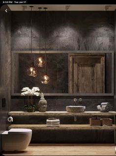 a bathroom with two sinks and lights hanging from the ceiling