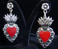 Based on the Mexican tin heart wall decorations, these solid metal cast earrings have a vintage silver finish with red resin heart filling. Though they're solid, the earrings are not very heavy. Metal "stud" type attachments with stopper included to help secure your earrings better. Though they're solid metal, they're not very heavy. If you're concerned, we do offer a mini "stud" version in this style. Click HERE to see them. They measure about 1.2" W x 2" H Another cool design brought to you by Mexican Folk Art Decor, Mexican Papel Picado, Sacred Heart Art, Ring My Bell, Blue Stone Ring, Cut Paper, Silver Jewelry Rings, Heart Art, Metal Earrings