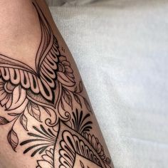 a close up of a person's leg with tattoos on it and an intricate design