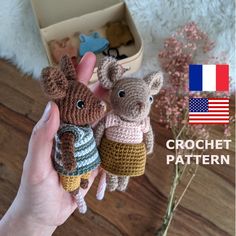 two small crocheted mice are held up in front of an american flag background