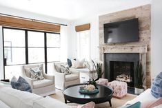 a living room filled with furniture and a flat screen tv mounted on the wall above a fire place