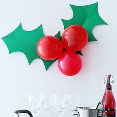 two red balloons are hanging on the wall next to some wine glasses and a bottle