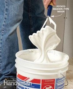 a person using a sharp knife to paint a bucket