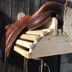 a pair of brown leather shoes sitting on top of a wooden bench