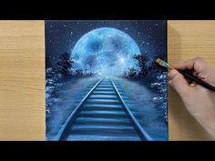 a person is painting a train track at night with the moon in the sky above