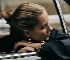 a woman sitting in the back seat of a car with her hand on her shoulder