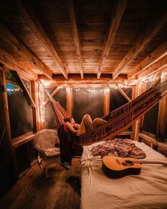 a person laying in a hammock with a guitar