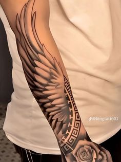 a man's arm with an eagle and rose tattoo on the left side of his arm