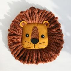 a lion head made out of yarn on a white surface