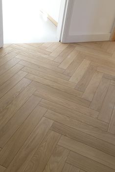 an empty room with wood flooring and white door