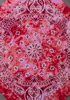 a red and white tie - dyed rug with an intricate design on the center piece