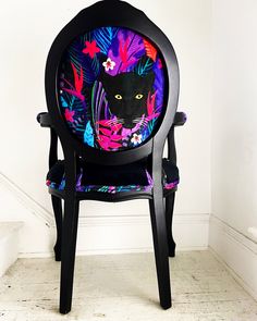 a chair with a black cat painted on it