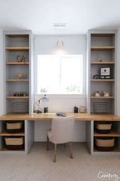 a home office with built - in shelving and storage baskets on the desk area