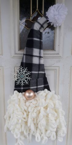 a door hanger with a black and white striped scarf on it's head