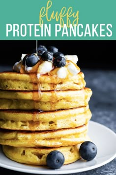 a stack of pancakes topped with blueberries and syrup