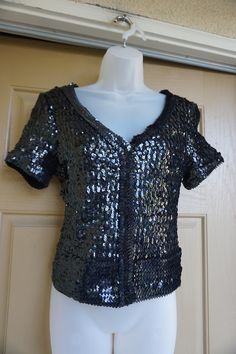 "What a Awesome top!! You'll be sure to catch everyone's attention when you show up to the party in this little number! All over sequin detailing makes this shirt ready for any night on the town. Made Cache. labeled Medium Good vintage condition. Measurements taken across front laid flat - stretchy 18\" across front armpit to armpit 15\" across waist 20\" length" Embellished Short Sleeve Tops For Party Season, Disco Style Sequin Tops For Night Out, Short Sleeve Sequined Tops For Fall, Short Sleeve Top With Sequins For Fall, Fall Short Sleeve Top With Sequins, Short Sleeve Tops With Sequins For Fall, Fitted Disco Top For Holidays, Black Fitted Disco Top, Fitted Black Disco Tops