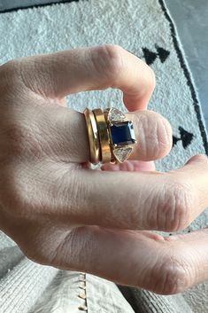 a woman's hand with two rings on top of her finger, and the other ring