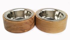 two wooden bowls with stainless steel lids are shown on a white background the bowl is made out of wood and has metal rims