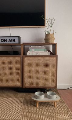 a tv stand with two bowls on top of it