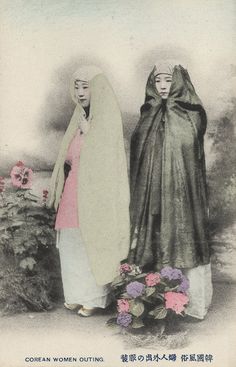 two women dressed in black and white are standing next to each other with their heads covered