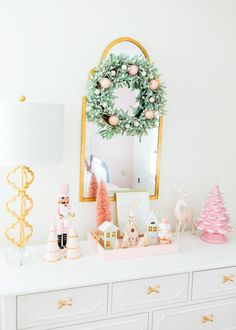 a white dresser topped with lots of christmas decorations