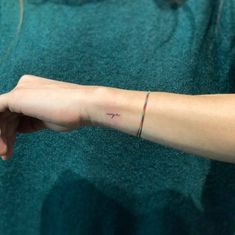 a woman's arm with a small tattoo on the left side of her wrist