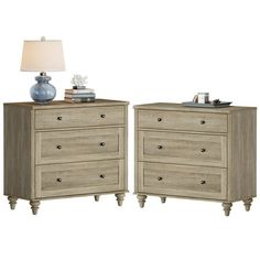 two nightstands with drawers on each side and a lamp next to them, both in light wood