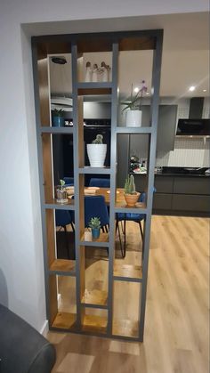 an open bookcase in the middle of a room with blue chairs and wooden floors