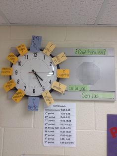 a clock that is on the wall with post it notes attached to it's sides