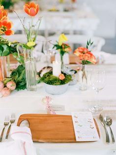 the table is set with flowers and place settings