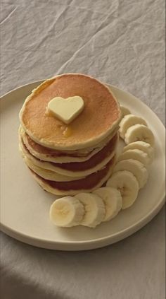 a stack of pancakes topped with butter and sliced bananas