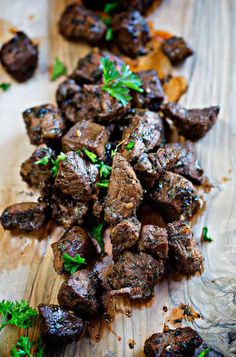 the meat is cut up and ready to be eaten on the cutting board with parsley