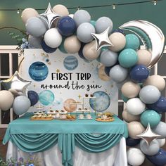 the first trip around the sun table is set up with balloons and desserts on it