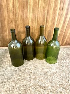 four wine bottles are lined up on the floor