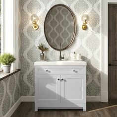 a bathroom vanity with a round mirror above it and wallpaper on the walls behind it