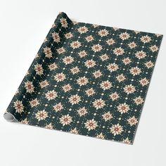 a green wrapping paper with white and red flowers on it, sitting on top of a table