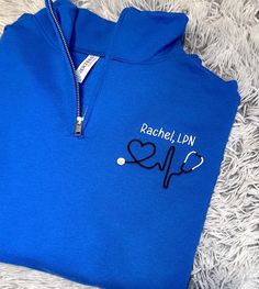 I'm so excited to offer this Personalized Nurse Name quarter zip Embroidered pullover sweatshirt!!  Being a registered nurse myself, I worked in a hospital for years and know how cold those units can be!! Perfect for nurses, patient care techs, doctors or any medical/nursing licensed professionals. Makes a great gift! Choose your own thread colors for stethoscope and name!!  Sweatshirt shown is Oxford with Light Salmon Pink thread stethoscope and Black Heather with Cool Aqua thread. Choose your own thread colors and font from Thread Color Chart! Quarter Zip Sweatshirt Colors Available: ASH GRAY BLACK BLACK HEATHER NAVY ROYAL BLUE OXFORD MAROON WHITE All items are embroidered by me, in my home, so you can be sure that each and every item is made with care and great attention to detail! Proc Medical Nursing, Embroidered Pullover, Name Sweatshirt, Sweatshirt Colors, Oncology Nursing, Pink Thread, Patchwork Sweater, Light Salmon, Ash Gray