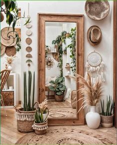 a mirror sitting on top of a wooden table next to potted plants and other decorations