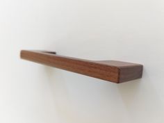 a wooden shelf mounted to the side of a wall