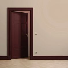 an empty room with a red door and white walls