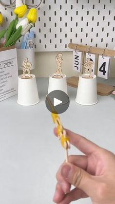 a person holding a toothbrush in front of some small figurines on a desk