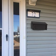 a house with a mailbox and number on the front door that is painted white